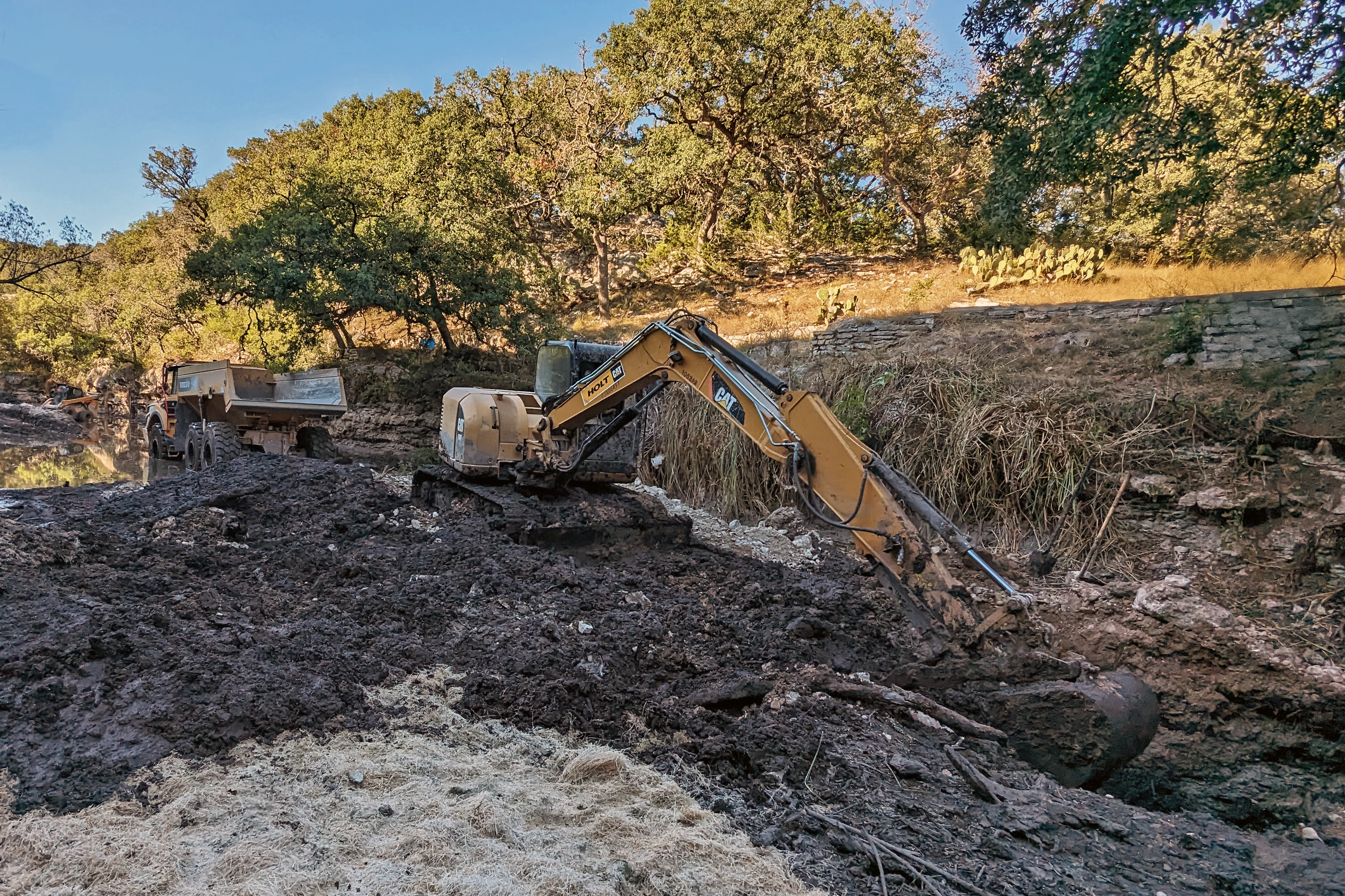 Excavator digging in the mud.